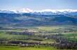 view on Sudety with snowy Karkonosze mountains with green meadows during spring in Poland