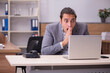 © Elnur - Young male employee working in the office