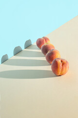 Wall Mural - Creative summer composition with fresh peach fruits against bright beige background. Minimal food concept. Creative summer sunny day scene.