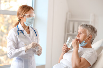 Sticker - Doctor giving remedy to senior woman in clinic