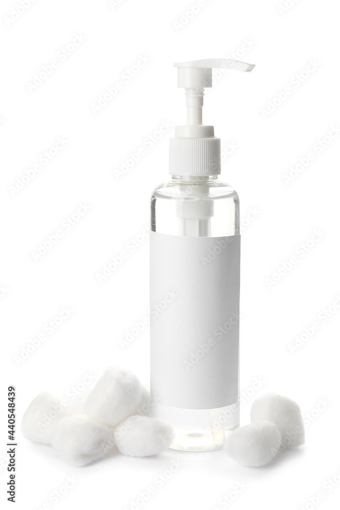 Soft cotton wool and cosmetic bottle on white background