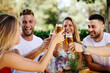 © djile - Group of happy friends toasting with beer at the summer bar
