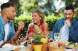© djile - Group of young happy people having lunch at a restaurant during a sunny summer day