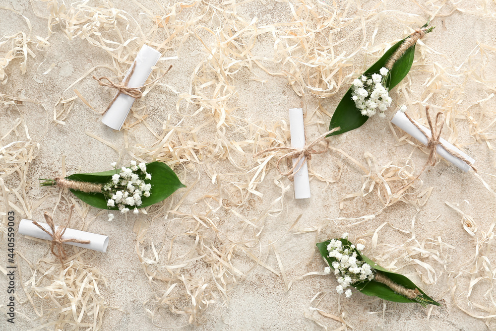 Beautiful gypsophila boutonnieres and wedding invitations on grunge background