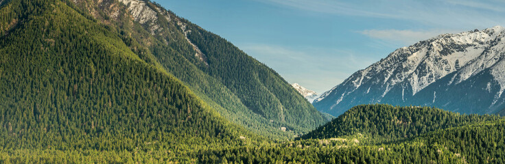 Wall Mural - Panoramic landscape view, snow covered mountain peaks on mountain range. Hills and mountains covered with green pine forest, Arkhyz villadge, Caucasus mountains, Russia