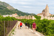 © MiguelAngel - Group of men walking with donkeys, with the monastery of Santa María de la Valldigna in the background.