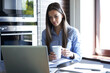 © ty - Smiling pretty woman sitting at table, looking at laptop screen. Happy entrepreneur reading message email with good news, chatting with clients online.