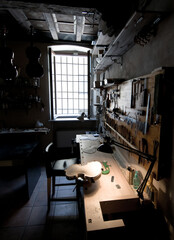 Sticker - Vertical shot of a poorly lit violin workshop with a violin body under a lamp lighting