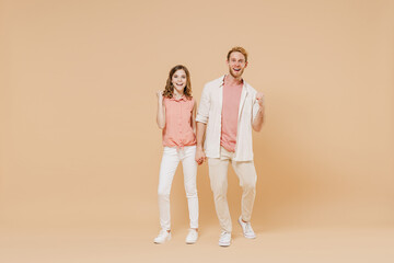 Wall Mural - Full length happy overjoyed young parent man have fun with cute child teen girl in casual pastel clothes. Daddy little kid daughter do winner gesture clench fist isolated on beige color background