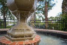 Close Up Of Water Splashing On Fountain In Gated Garden