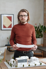 Poster - Portrait of creative architect comparing sketch and maquette