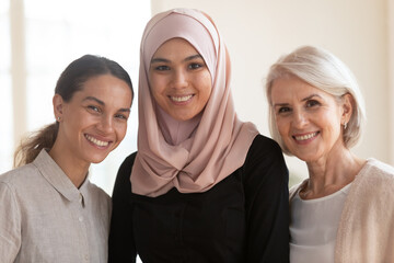 Wall Mural - Head shot portrait smiling diverse colleagues with Asian muslim businesswoman wearing hijab, team leader executive looking at camera, happy multiethnic employees posing for photo together