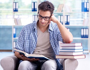 Student reading books and preparing for exams in library