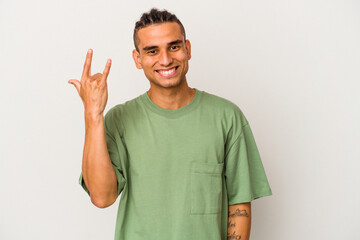 Young venezuelan man isolated on white background showing rock gesture with fingers