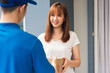 © sorapop - Asian young delivery man courier in uniform hold parcel post boxes service shipment woman customer receiving accepting parcel from delivery at front home, Online shopping service concepts
