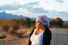 Woman  With Head Wrap Looking In To The Distance In Late Afternoon Sun