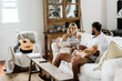 © Austockphoto - Happy couple relaxing on a couch talking, reading and drinking coffee