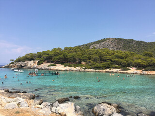 Aponisos beach, a pebble beach in a small cove with sheltered swimming, seen from Aponisos Island in the vicinity of Agistri, Greece. 