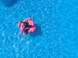 © Marharyta - Beautiful summer background. Aerial drone view of woman in pool with flamingo float in hotel. Summer holidays, enjoying summer vacations during quarantine.