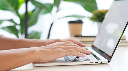 Wall Mural - close up of man hand typing laptop computer while working at home office, student college online stu