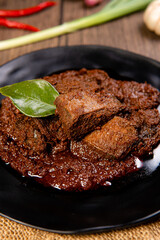 Wall Mural - Beef Rendang is a Minang dish originating from the Minangkabau region in West Sumatra, Indonesia.  Rendang has been slow cooked and braised in a coconut milk seasoned with a herb and spice mixture