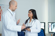 © DragonImages - Physicians standing in medical office and discussing symptoms and possible diagnosis of patient