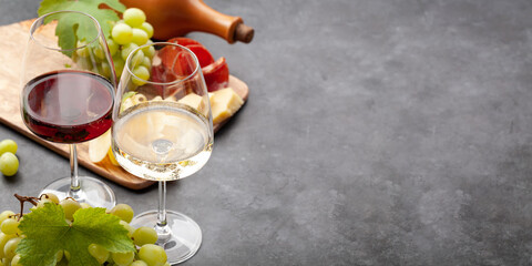 White and red wine glasses, grape and appetizer board