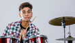 © Bangkok Click Studio - Close-up portrait shot of a teenage drummer playing the music. Selective focus at the drum with a drummer isolated on white background. Professional junior student playing an instrument as a hobby