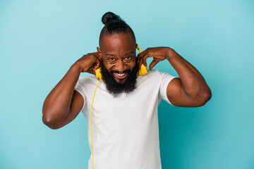 African american man listening to music isolated on blue background