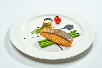 Wall Mural - Grilled salmon steak with asparagus and balsamic sauce in a white plate. Isolated on white background. View from above