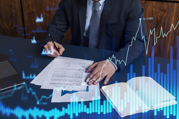 Wall Mural - A client in formal wear is signing the contract to invest money in stock market. Internet trading and wealth management concept. Forex and financial hologram chart over the desk.