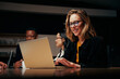 Smiling young businesswoman using laptop with team in the background
