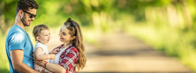 Young parents with daughter enjoying moments together in the park