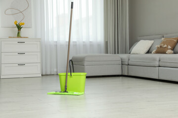 Wall Mural - Mop and bucket on wooden floor in living room. Cleaning service