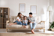 © New Africa - Happy family with little daughter sitting on sofa in living room