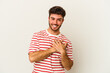 © Asier - Young caucasian man isolated on white background laughing keeping hands on heart, concept of happiness.