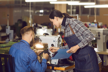 Female quality control manager talking to shoemaker sewing leather working at workplace. Woman master supervisor and craftsman coworking. Shoe factory, footwear industry and manufactory