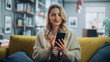 © Gorodenkoff - Beautiful Caucasian Female Using Smartphone in Stylish Living Room while Resting on a Cozy Couch Sofa. Young Woman at Home, Browsing Internet, Using Social Networks, Having Fun in Flat.