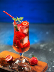 Wall Mural - strawberry refreshing ice tonic cocktail in a glass with a red straw