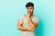 © Asier - Young caucasian man isolated on blue background confused, feels doubtful and unsure.