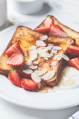 Canvas Print - French toast with strawberries, yogurt and maple syrup on a white plate. Breakfast concept.