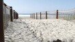 Pacific ocean coast, greenery and wooden picket fence on sea shore. Blue water waves on sunny summer beach, Encinitas shoreline, California USA. Coastline near Los Angeles. Coastal access entrance.