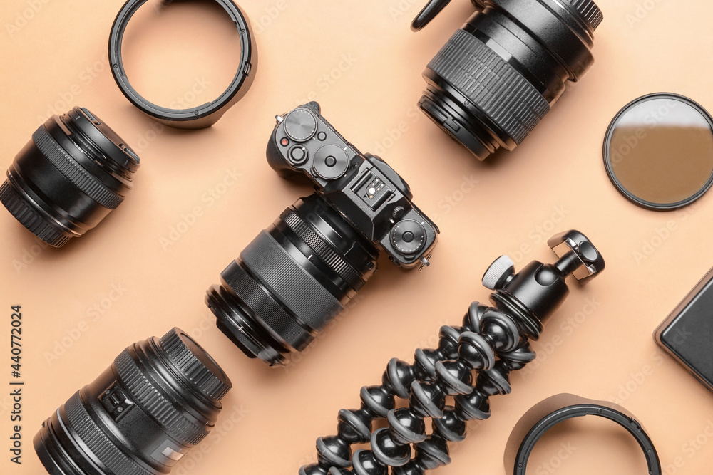 Modern photographer's equipment on color background