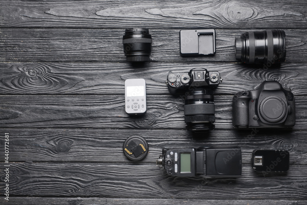 Modern photographer's equipment on dark wooden background