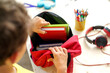 schoolboy puts office supplies in a backpack. Preparing for school. Back to school. Self-assembly of a school backpack. Close-up