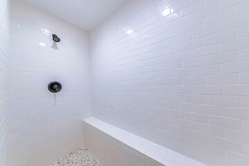 Sticker - White-tiled shower area with a sitting space