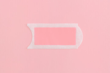 Pink waxing strips on pink background. Top view with copy space. Flat lay composition.