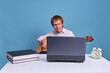© Андрей Журавлев - Student plays acoustic guitar while sitting at laptop, blue studio background
