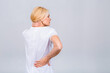 Mature senior old beautiful woman wearing casual suffering from back pain. Empty blank copy space with backache concept. Isolated over white grey background