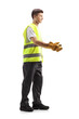 © Ljupco Smokovski - Full length profile shot of a young waste collector in a uniform and gloves gesturing with hands